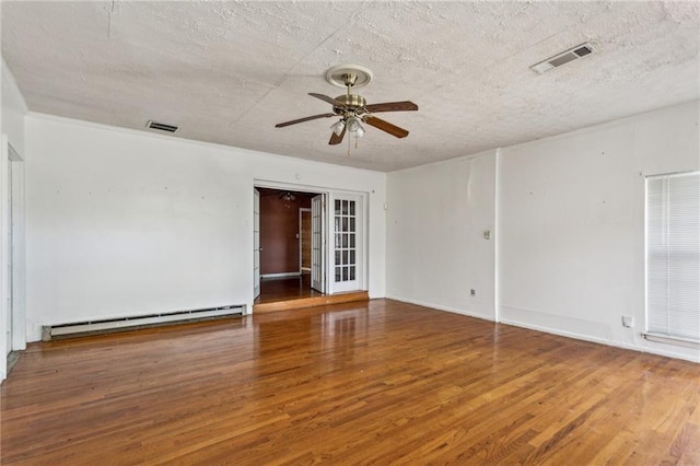 empty room with wood-type flooring, a textured ceiling, ceiling fan, and baseboard heating