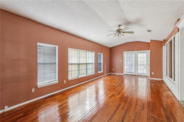 unfurnished room featuring wood-type flooring, lofted ceiling, a textured ceiling, and ceiling fan