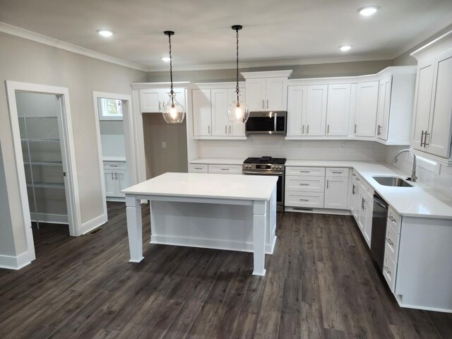 kitchen featuring a kitchen island, pendant lighting, sink, white cabinetry, and appliances with stainless steel finishes