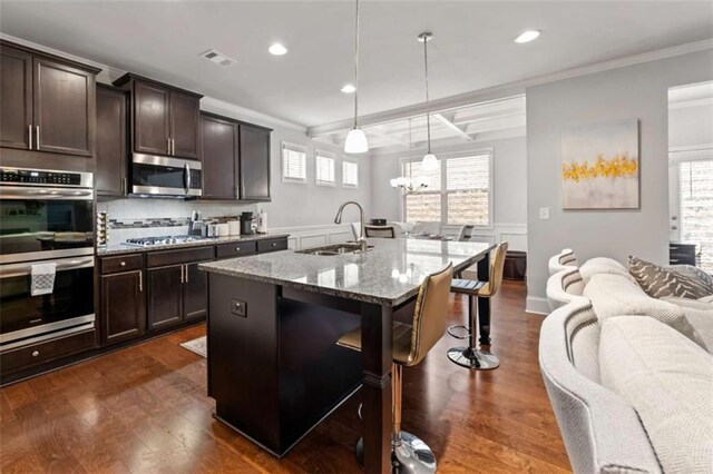 736 Red Wolf Run, Atlanta, GA 30349 - kitchen featuring light stone counters, visible vents, a breakfast bar, a sink, and appliances with stainless steel finishes