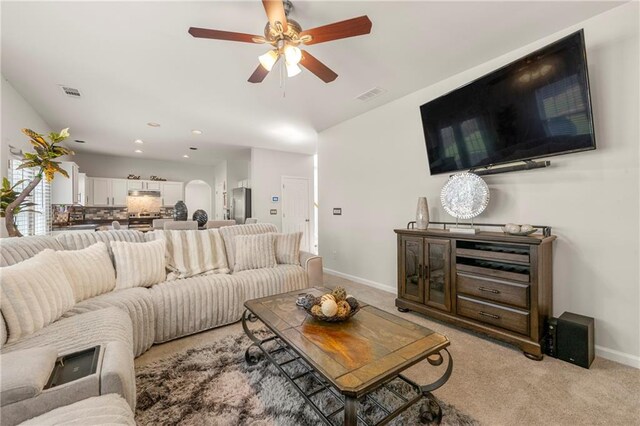 carpeted living room with ceiling fan