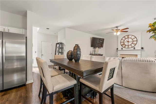 dining area with dark wood-type flooring and ceiling fan