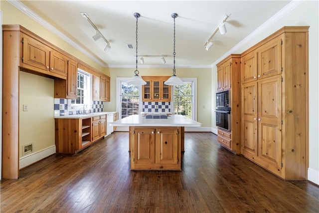 kitchen with a center island, ornamental molding, backsplash, and dark wood-type flooring