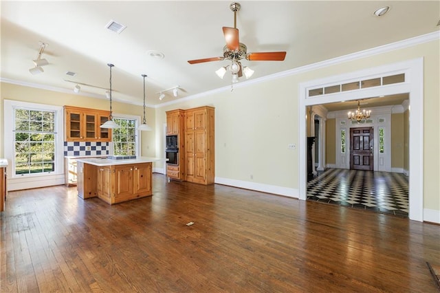 kitchen featuring ceiling fan with notable chandelier, a center island, and ornamental molding