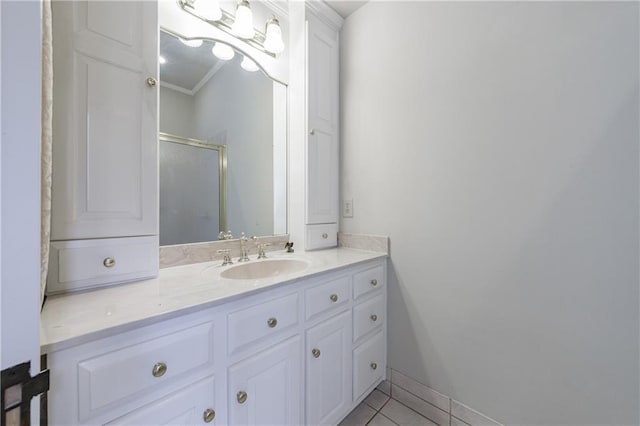 bathroom featuring tile patterned floors, crown molding, vanity, and a shower with shower door