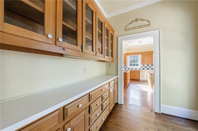 bar featuring decorative backsplash, crown molding, and dark wood-type flooring