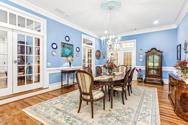 317 Red Gate Overlook, Canton, GA 30115 - dining room with french doors, a chandelier, wainscoting, wood finished floors, and crown molding