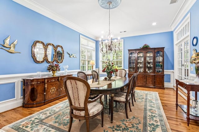 317 Red Gate Overlook, Canton, GA 30115 - dining space with a chandelier, ornamental molding, a wainscoted wall, wood finished floors, and a decorative wall