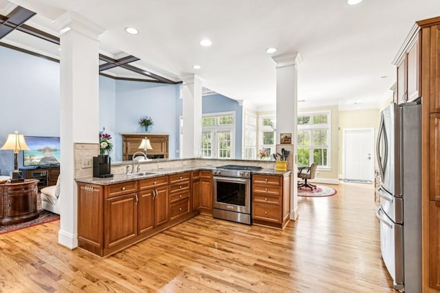 317 Red Gate Overlook, Canton, GA 30115 - kitchen featuring stainless steel appliances, decorative columns, crown molding, light wood-type flooring, and light stone countertops