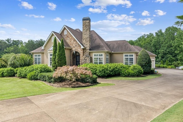 317 Red Gate Overlook, Canton, GA 30115 - view of front of house with stucco siding, a front lawn, a chimney, stone siding, and a garage