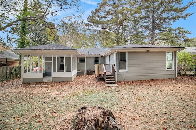 back of property with central air condition unit and a sunroom