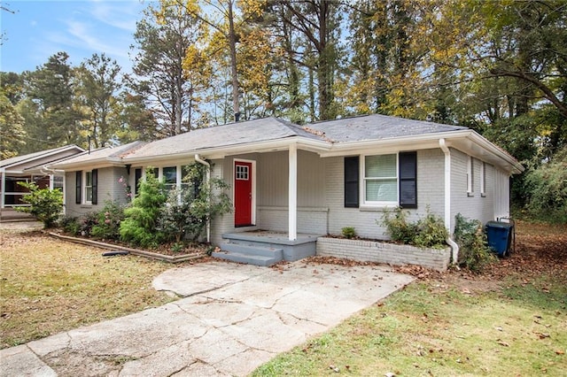 ranch-style house with a porch and a front lawn