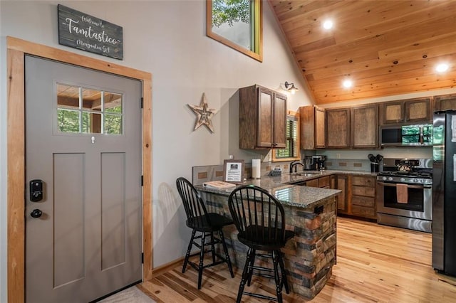 68 Whispering Hawk Ct, Morganton, GA 30560 - kitchen featuring appliances with stainless steel finishes, a peninsula, wood ceiling, dark stone counters, and light wood finished floors