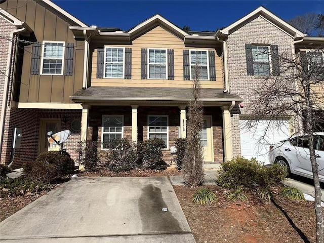 townhome / multi-family property featuring covered porch, brick siding, board and batten siding, and an attached garage