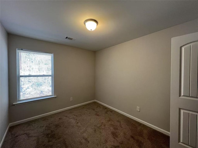 carpeted empty room featuring visible vents and baseboards