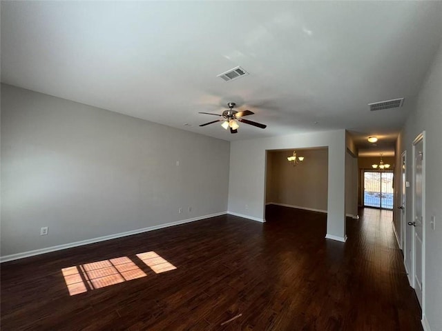 unfurnished room with dark wood-type flooring, visible vents, baseboards, and ceiling fan with notable chandelier