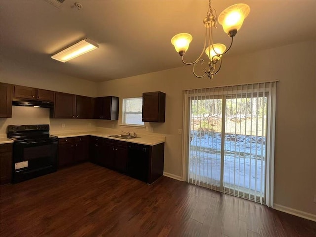 kitchen featuring a sink, dark wood-type flooring, light countertops, and black range with electric stovetop