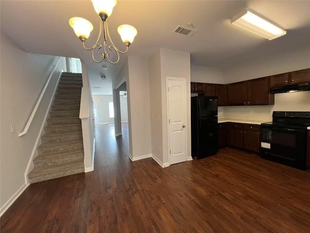 kitchen featuring dark brown cabinetry, under cabinet range hood, visible vents, black appliances, and dark wood finished floors