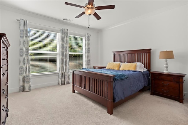 bedroom featuring light colored carpet, a ceiling fan, baseboards, and crown molding