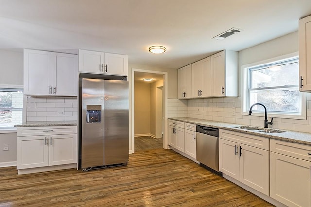 kitchen featuring appliances with stainless steel finishes, dark hardwood / wood-style flooring, white cabinets, and sink