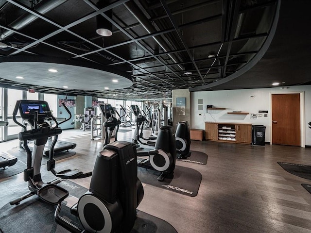 exercise room featuring floor to ceiling windows and wood finished floors