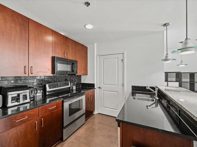 kitchen with a sink, dark wood-style flooring, black microwave, decorative backsplash, and electric stove