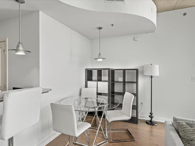 dining room with baseboards, visible vents, and wood finished floors