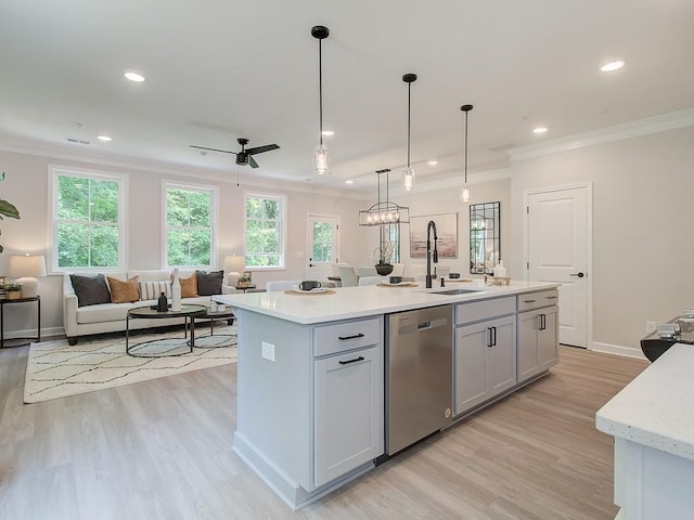 kitchen with sink, dishwasher, ornamental molding, an island with sink, and decorative light fixtures