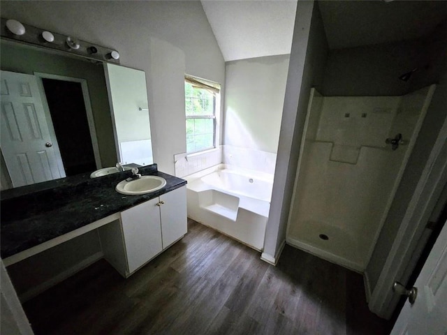 bathroom with vanity, lofted ceiling, hardwood / wood-style flooring, and plus walk in shower