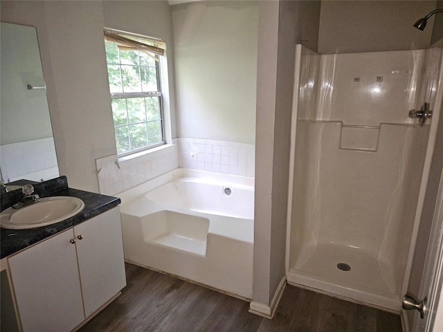 bathroom featuring vanity, hardwood / wood-style floors, and plus walk in shower