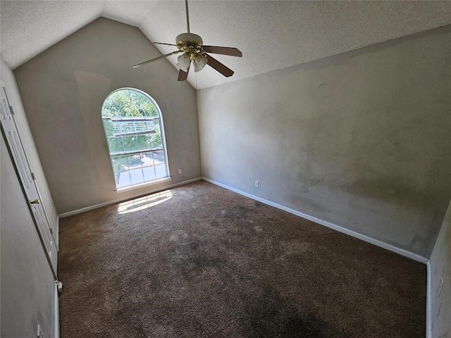 unfurnished room featuring vaulted ceiling, a textured ceiling, carpet floors, and ceiling fan