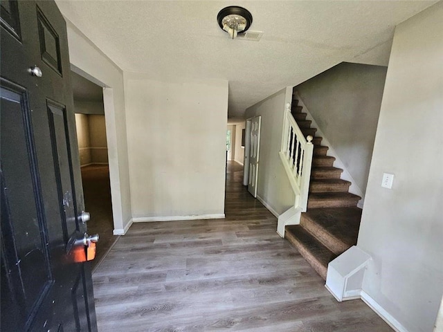 foyer entrance featuring a textured ceiling and hardwood / wood-style flooring