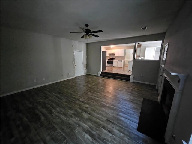 unfurnished living room with ceiling fan and dark hardwood / wood-style flooring