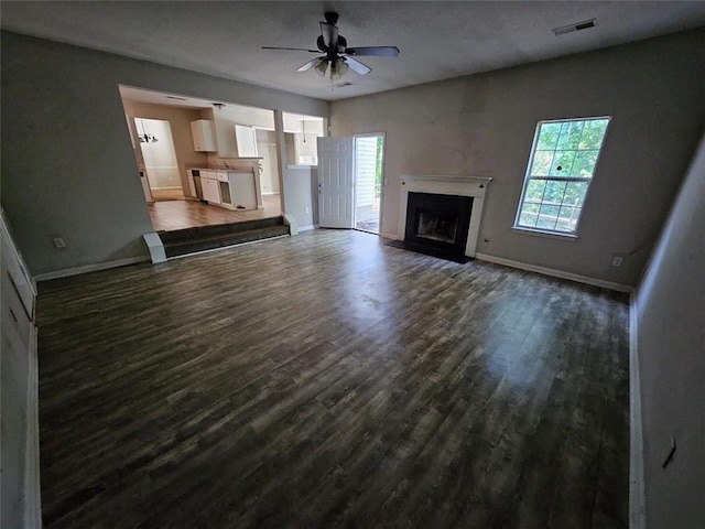 unfurnished living room featuring ceiling fan and dark hardwood / wood-style flooring