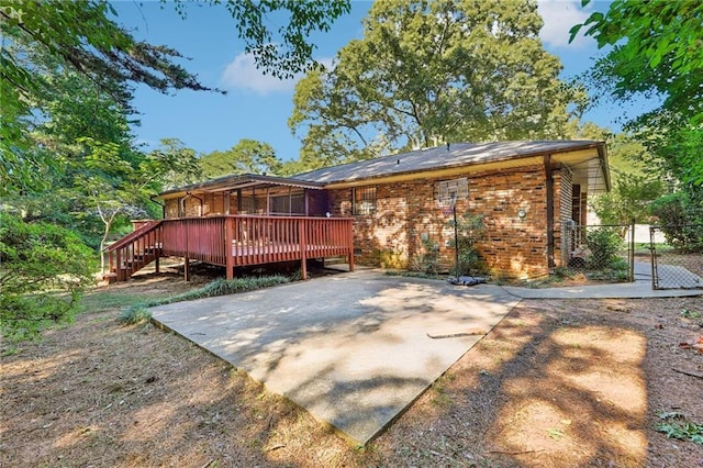 back of property with a deck and a patio