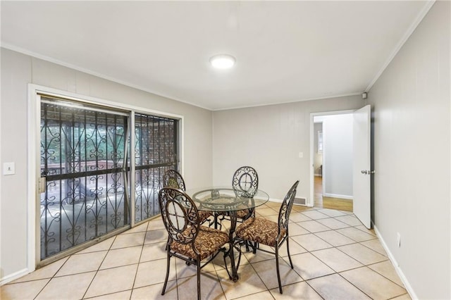 dining space featuring ornamental molding and light tile patterned floors