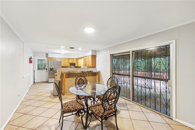 dining area with ornamental molding and light tile patterned floors