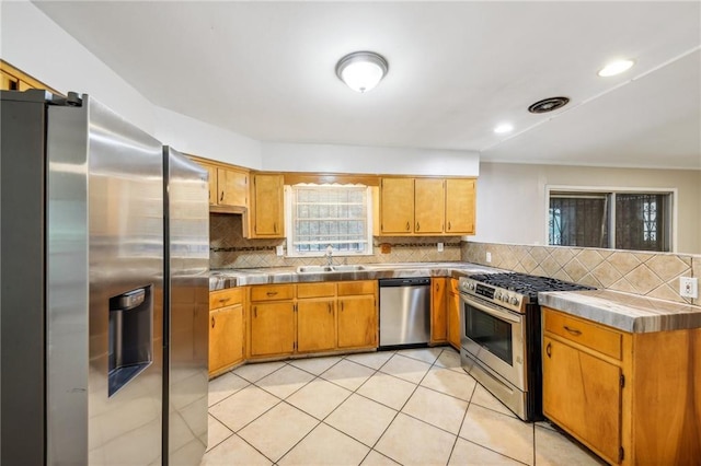 kitchen with stainless steel appliances, sink, light tile patterned floors, and backsplash