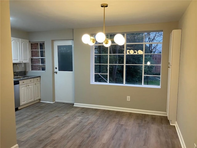 unfurnished dining area featuring plenty of natural light, dark wood-type flooring, and sink