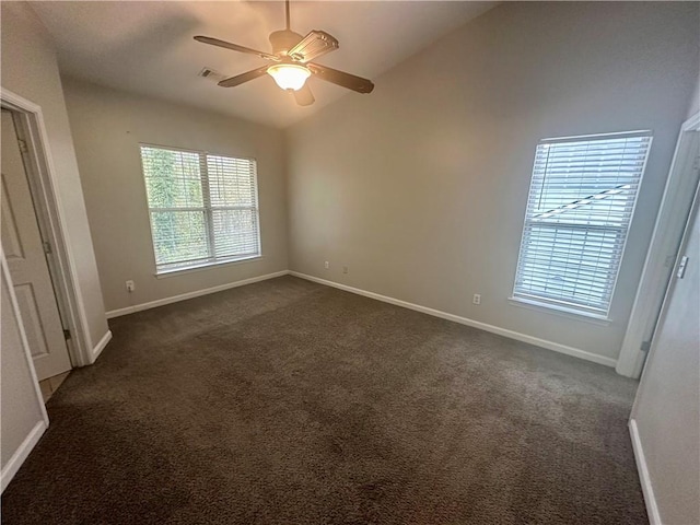 unfurnished room with ceiling fan, lofted ceiling, and dark carpet