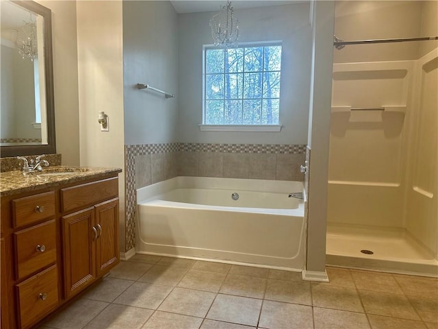 bathroom with vanity, a tub to relax in, tile patterned flooring, and an inviting chandelier