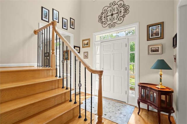 entrance foyer with a high ceiling, stairs, and wood finished floors