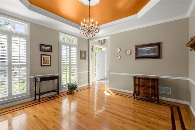 entryway featuring baseboards, a notable chandelier, visible vents, and wood finished floors