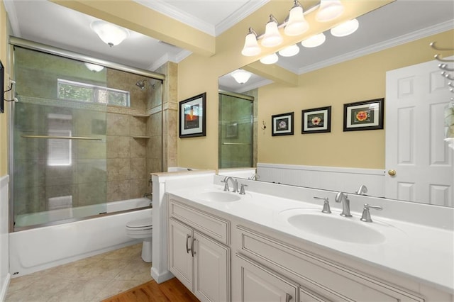 bathroom featuring a sink, crown molding, toilet, and double vanity
