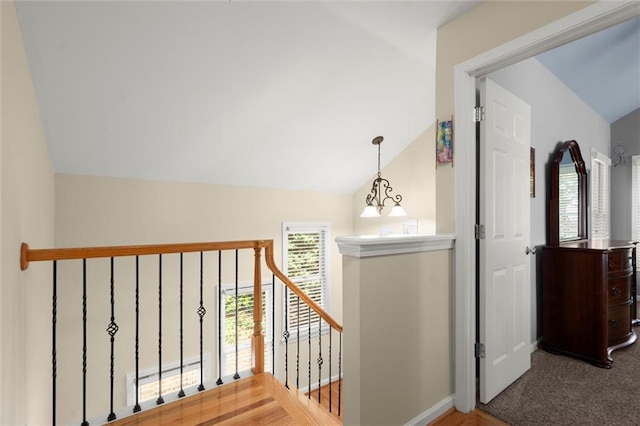 corridor with baseboards, carpet floors, vaulted ceiling, and an upstairs landing