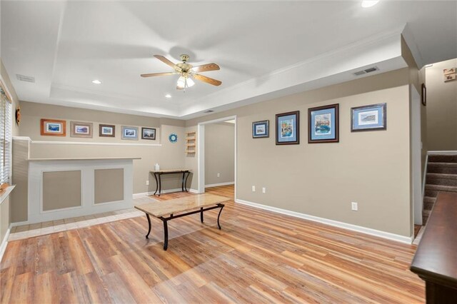 rec room featuring light wood-style flooring, a ceiling fan, recessed lighting, a tray ceiling, and visible vents