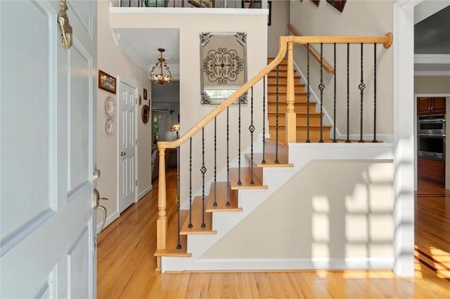 foyer featuring stairs, wood finished floors, and a chandelier