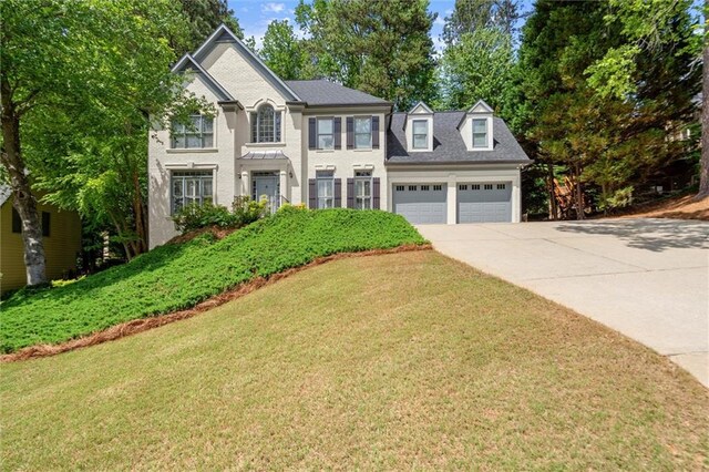 view of front facade with a garage, a front yard, and concrete driveway