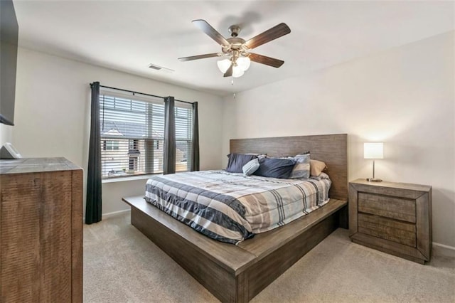 bedroom featuring light carpet, baseboards, visible vents, and ceiling fan