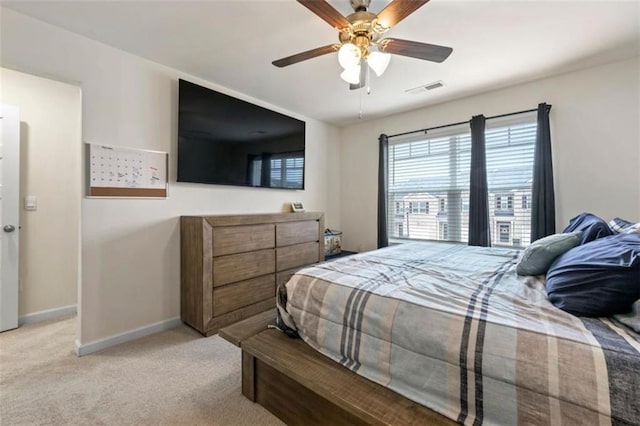 bedroom with baseboards, visible vents, ceiling fan, and light colored carpet